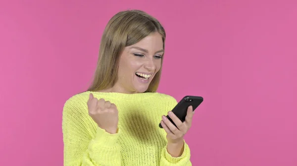 Excited Girl Cheering Success while Using Smartphone, Pink Background