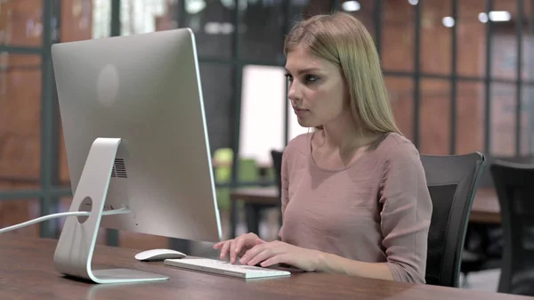 Амбициозная молодая женщина, работающая за компьютером — стоковое фото