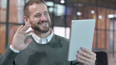 Tablet 'te video sohbeti yapan genç adamın portresi.