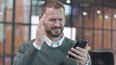 Smartphone kullanan Hayal kırıklığına uğramış adamın portresi 