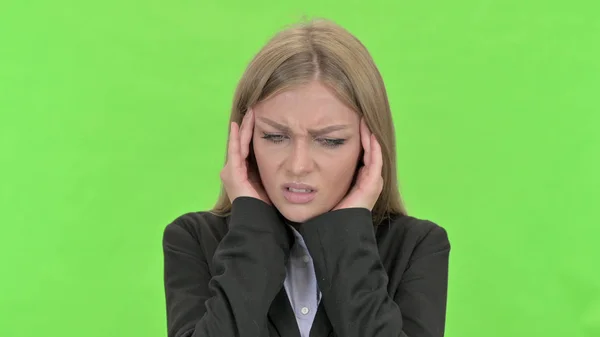 Tired Young Businesswoman having Headache against Chroma Key — Stock Photo, Image