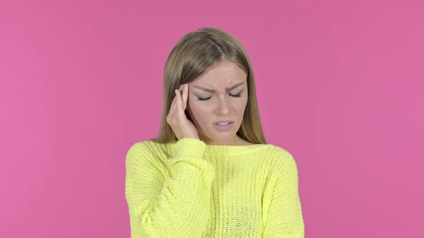 Stressato giovane ragazza avendo mal di testa, sfondo rosa — Foto Stock