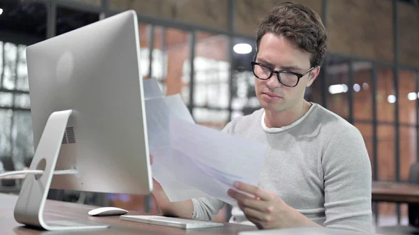 Nagyratörő Guy Reading Document on Office Desk — Stock Fotó