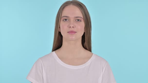 Junge Frau freut sich auf Überraschung, blauer Hintergrund — Stockvideo