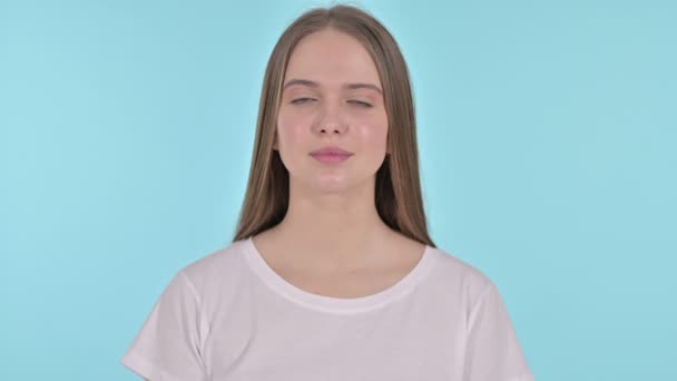 Uitnodigende mooie jonge vrouw wijzende vinger, blauwe achtergrond — Stockvideo