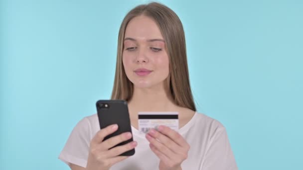 Pagamento on-line em Smartphone por mulher jovem, fundo azul — Vídeo de Stock