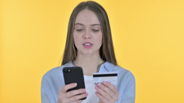 Online Betalning på smartphone av ung kvinna, gul bakgrund — Stockvideo