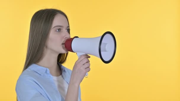 Mooie vrouw kondigt aan op luidspreker, gele achtergrond — Stockvideo