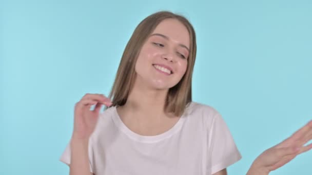 Mooie jonge vrouw dansen op muziek, blauwe achtergrond — Stockvideo