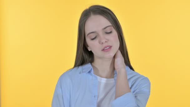 Mujer joven ocasional estresada con dolor de cuello, fondo amarillo — Vídeos de Stock