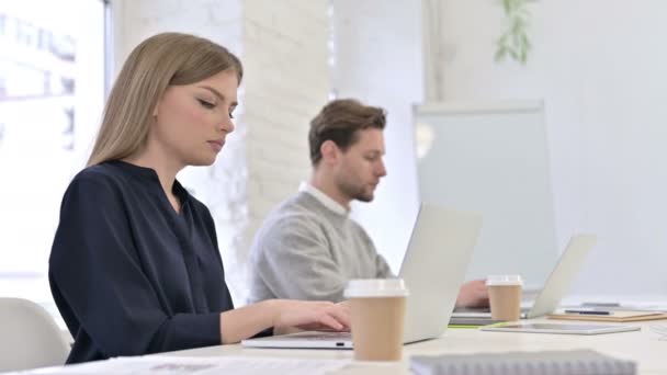 Atrakcyjny zespół kreatywny pracujący na laptopie i uśmiechnięty do kamery — Wideo stockowe