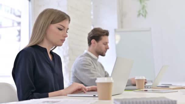 Skoncentrowany zespół kreatywny pracujący na laptopie w nowoczesnym biurze — Wideo stockowe