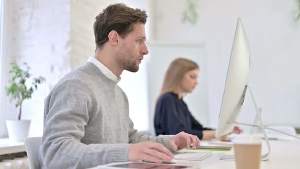 Uomo creativo concentrato che lavora sul desktop in ufficio moderno — Video Stock