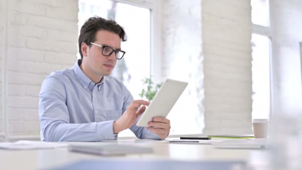 Atraktivní pracující mladý muž dělá video chat na tabletu — Stock video