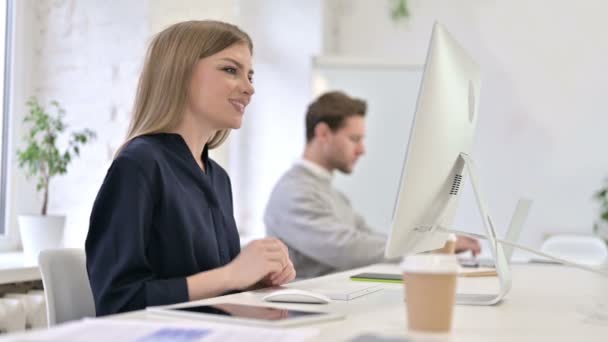 Schöne kreative Frau tut Video-Chat auf dem Desktop im Büro — Stockvideo