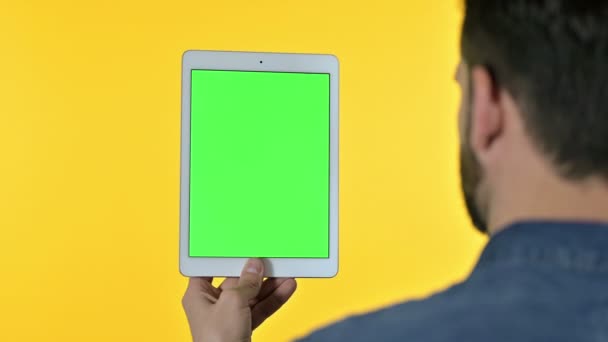 Man gebruikmakend van op Tablet met Chroma Scherm, Gele Achtergrond — Stockvideo