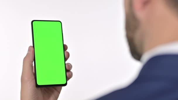 Zakenman op zoek naar Smartphone met Chroma Screen, Witte achtergrond — Stockvideo