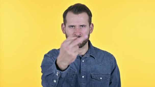 Wütender Bart junger Mann zeigt Mittelfinger, gelber Hintergrund — Stockvideo