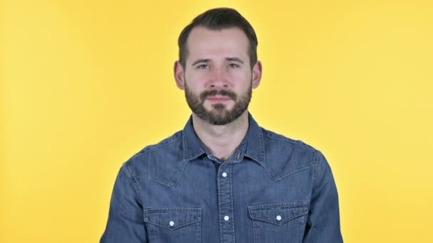 Knappe baard jonge man wijzend vinger en uitnodigende, gele achtergrond — Stockvideo