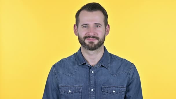 勝利の兆候を示す成功した若いビジネスマン,黄色の背景 — ストック動画