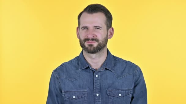 Homem jovem barba dizendo não por dedo, fundo amarelo — Vídeo de Stock