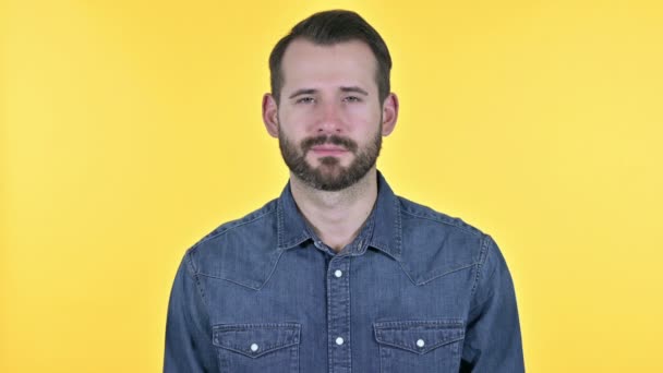 Joven alegre sonriendo a la cámara, fondo amarillo — Vídeos de Stock