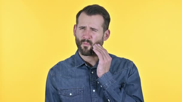 Baard jongeman met tandpijn, gele achtergrond — Stockvideo