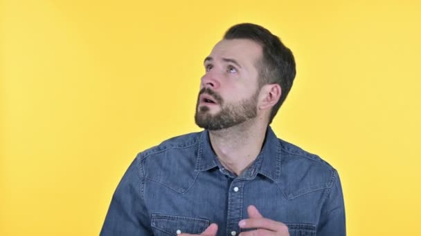 Ambitieuze baard jonge man op zoek naar kant manieren, gele achtergrond — Stockvideo