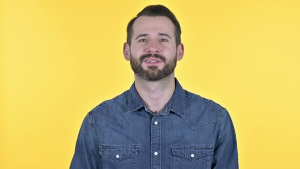 Baard jongeman doet video Chat, gele achtergrond — Stockvideo