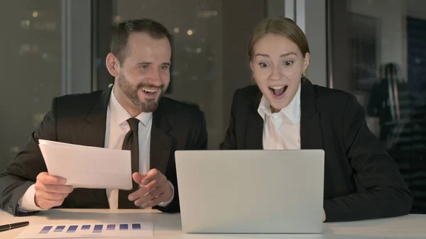 Geschäftsleute überrascht, während sie nachts am Laptop arbeiten — Stockfoto