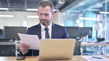 Ofis Masasında Belgeleri okuyan Genç İşadamı