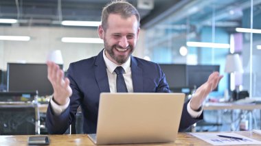 Şaşırmış genç iş adamı iki yumrukla kutlama yapıyor.