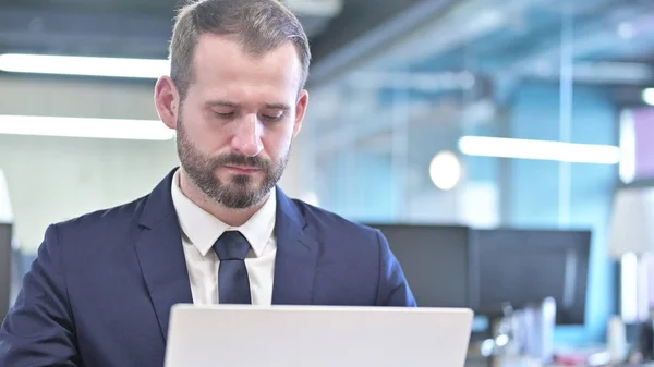 Le portrait d'un jeune homme d'affaires travaillant sur un ordinateur portable — Photo