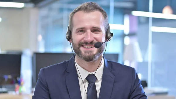 Het portret van een jonge zakenman glimlachend met een headset — Stockfoto