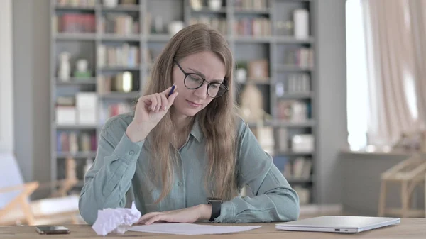 La joven trabajadora que piensa y escribe en papel — Foto de Stock