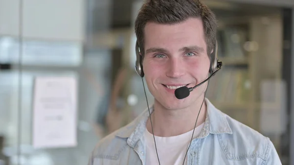 Portret pracownika Call Center noszącego słuchawki i uśmiechającego się — Zdjęcie stockowe