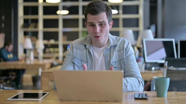 The Sad Young Designer Facing Loss on Laptop in Modern Office