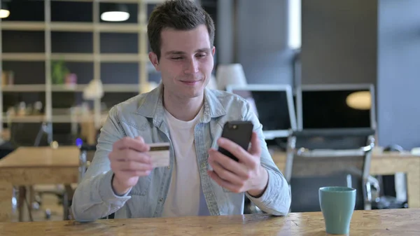 The Attractive Male Designer Successful at Online Payment on Smartphone