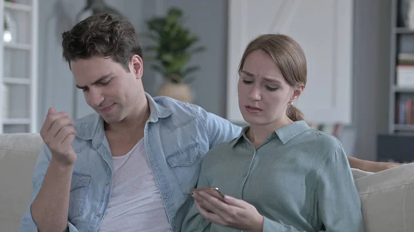 O retrato de casal decepcionado ficando perturbado ao usar Smartphone — Fotografia de Stock