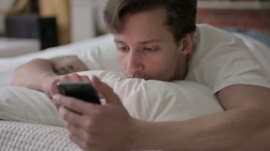 Yatakta Akıllı Telefon 'da Tembel Genç Adam Kaydırıyor