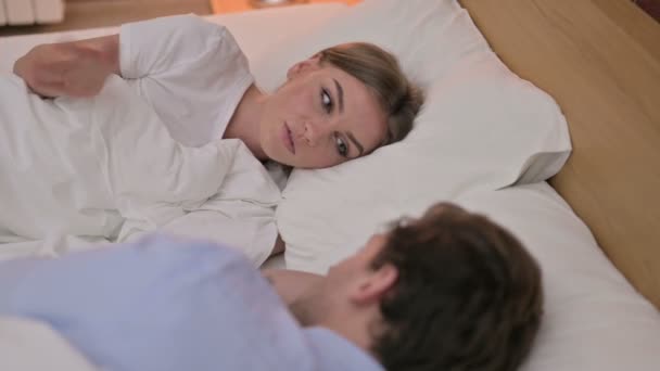 Zadní pohled veselý mladý pár s diskusí v posteli — Stock video