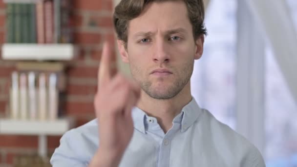Porträt eines jungen Mannes, der mit dem Finger auf die Kamera zeigt — Stockvideo