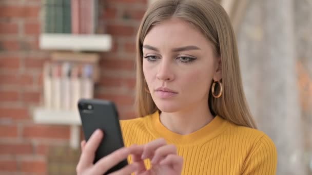 Retrato de una hermosa mujer joven celebrando el éxito en el teléfono inteligente — Vídeos de Stock