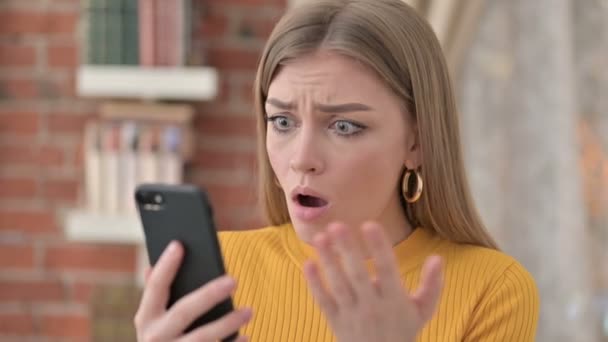 Portret van jonge vrouw reageert op verlies op smartphone — Stockvideo