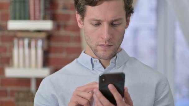 Retrato de Jovem Comemorando o Sucesso no Telefone — Vídeo de Stock