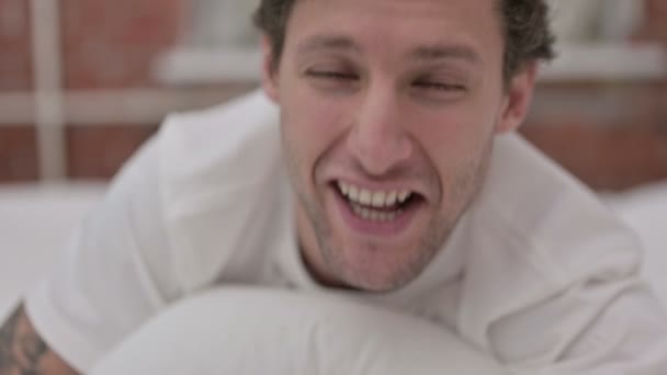 Портрет молодої людини, що робить відео чат у ліжку — стокове відео
