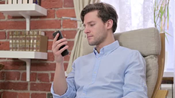 Jeune homme regardant la vidéo sur Smartphone — Video