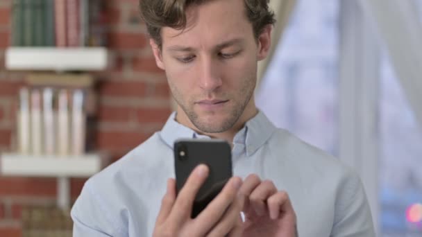 Окаменелый портрет молодого человека с помощью телефона — стоковое видео