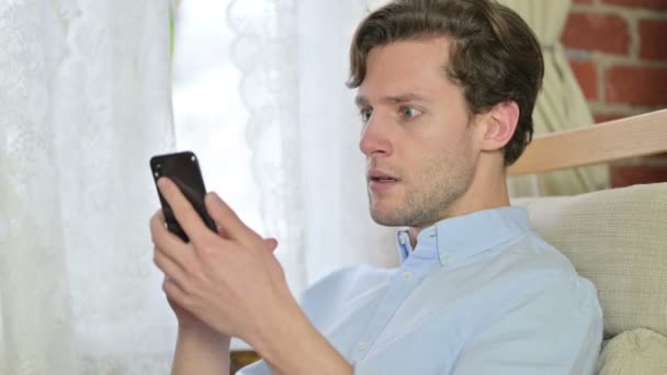 Retrato de hombre joven se decepcionan en el teléfono inteligente — Vídeo de stock