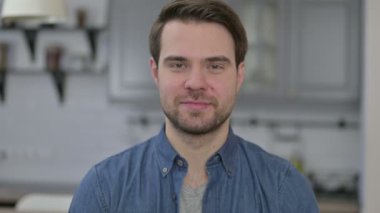 Sakallı genç adamın portresi Tamam işareti gösteriyor